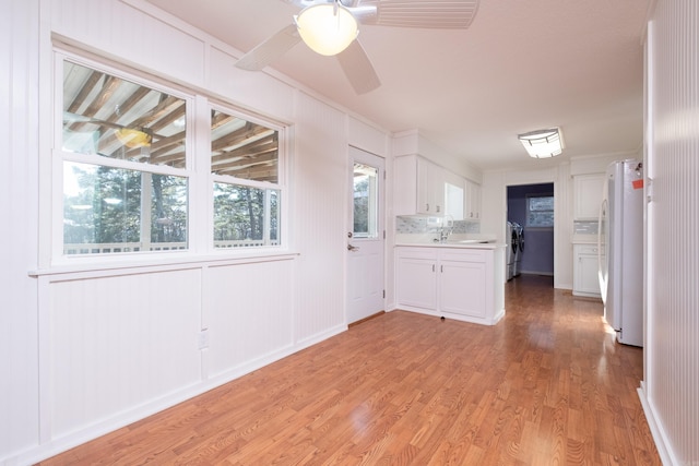 spare room featuring crown molding, ceiling fan, sink, and light hardwood / wood-style flooring