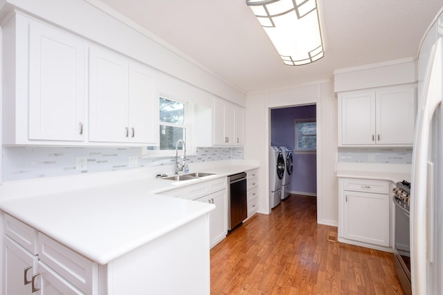 kitchen featuring separate washer and dryer, sink, white cabinets, stainless steel appliances, and light wood-type flooring