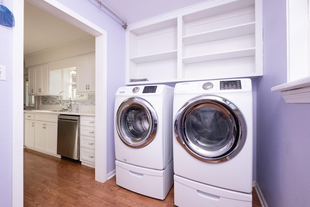 laundry room with crown molding, separate washer and dryer, sink, and dark hardwood / wood-style flooring