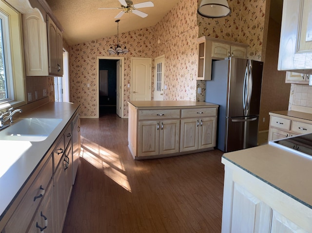 kitchen featuring dark hardwood / wood-style floors, pendant lighting, stainless steel refrigerator, sink, and ceiling fan