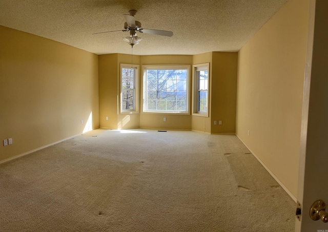 carpeted spare room with ceiling fan and a textured ceiling