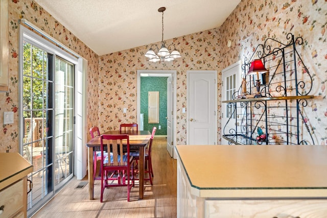 dining space featuring a notable chandelier and a textured ceiling