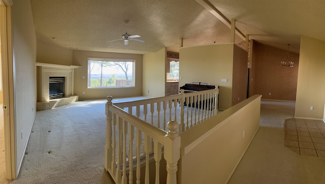 hall featuring light colored carpet, lofted ceiling, a chandelier, and a textured ceiling