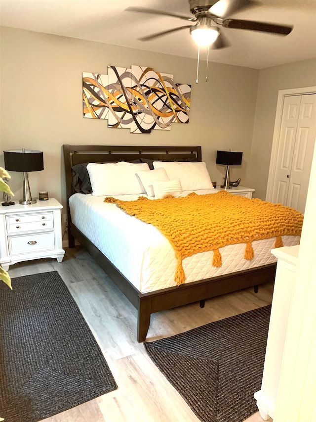 bedroom with hardwood / wood-style floors, a closet, and ceiling fan