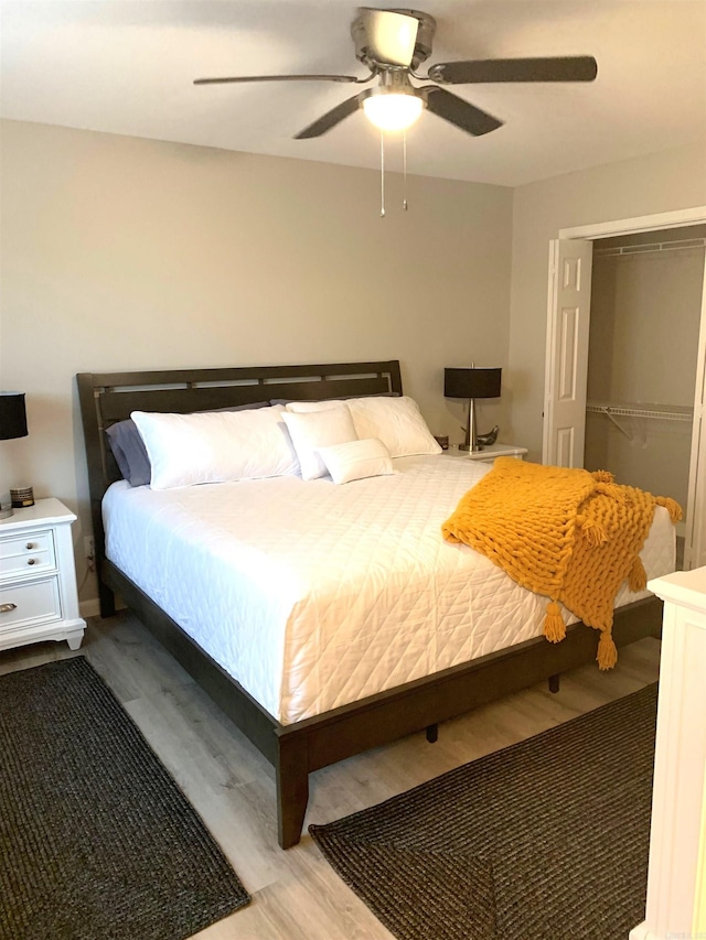 bedroom with ceiling fan, wood-type flooring, and a closet