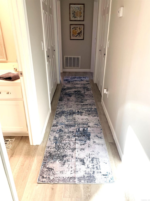 corridor with hardwood / wood-style floors