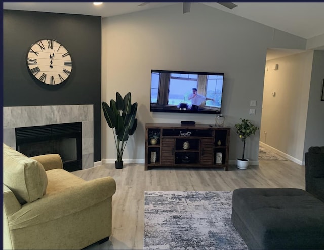 living room with hardwood / wood-style flooring, a tile fireplace, and vaulted ceiling with beams