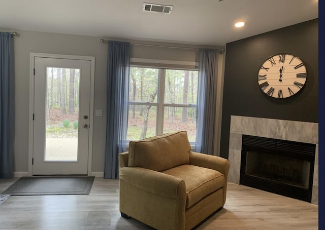 living area with a healthy amount of sunlight, a fireplace, and light wood-type flooring