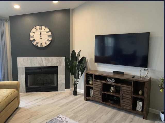 living room with a fireplace and light wood-type flooring