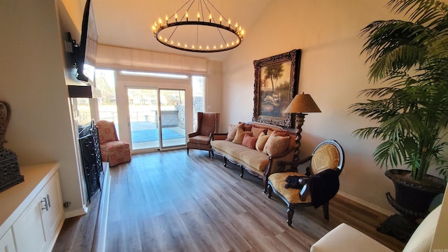 living area with an inviting chandelier and hardwood / wood-style flooring