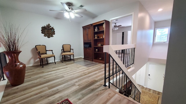 living area with ceiling fan and light wood-type flooring