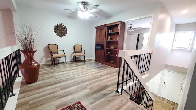 living area featuring ceiling fan and light hardwood / wood-style flooring