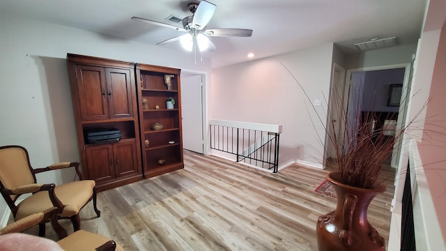 living area with ceiling fan and light hardwood / wood-style flooring