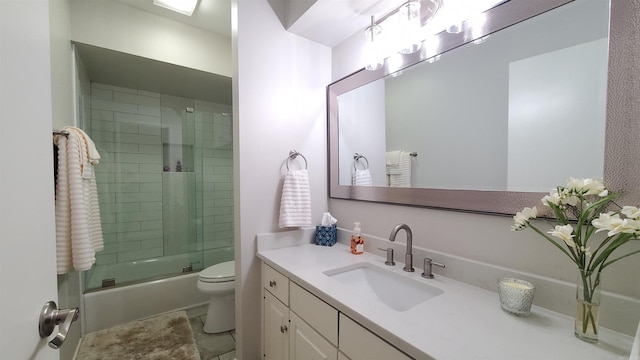 full bathroom with vanity, toilet, and combined bath / shower with glass door