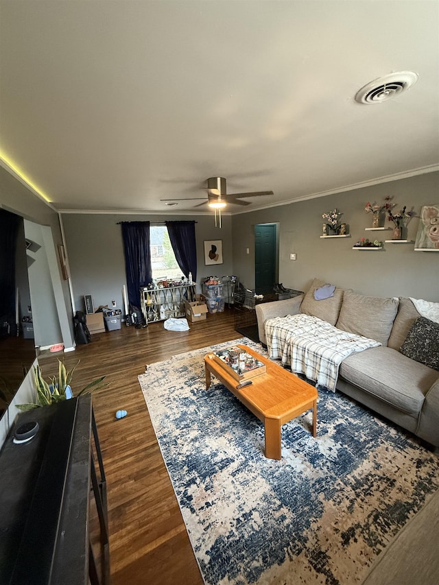 living room featuring ceiling fan, ornamental molding, and dark hardwood / wood-style floors