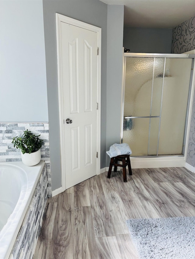 bathroom featuring wood-type flooring and plus walk in shower