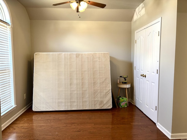 unfurnished bedroom featuring multiple windows, dark hardwood / wood-style flooring, lofted ceiling, and ceiling fan