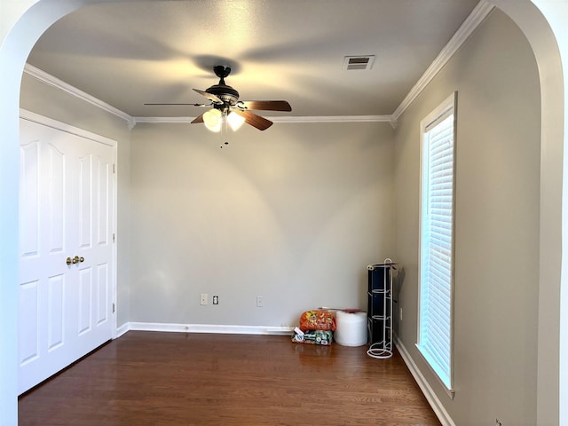 interior space with dark hardwood / wood-style flooring, ornamental molding, and ceiling fan