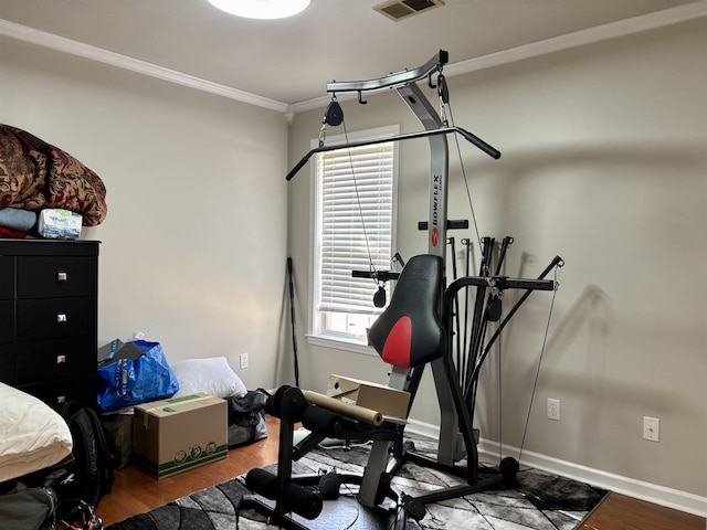 workout area featuring hardwood / wood-style flooring, crown molding, and a healthy amount of sunlight