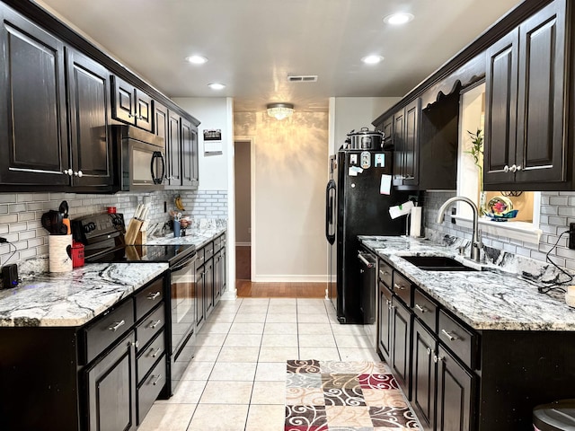 kitchen featuring light tile patterned floors, light stone countertops, sink, and black appliances