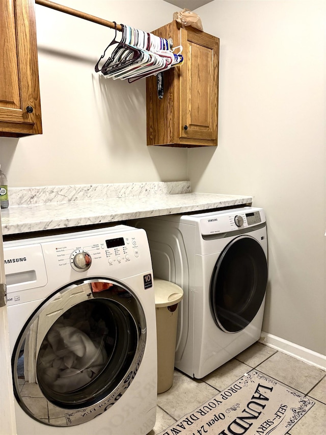 laundry room with cabinets, washing machine and clothes dryer, and light tile patterned flooring