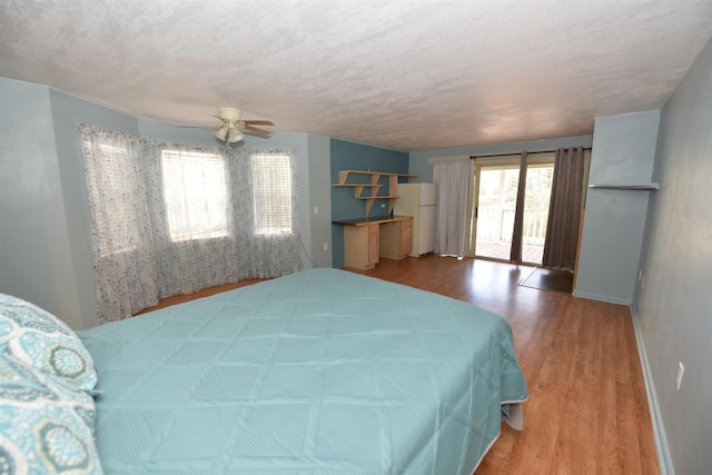 bedroom with hardwood / wood-style floors, ceiling fan, access to exterior, and white refrigerator