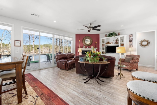 living room featuring ceiling fan and light wood-type flooring