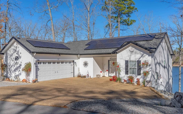 ranch-style house featuring a garage and solar panels