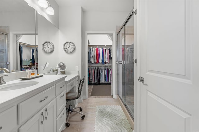 bathroom with walk in shower, vanity, and tile patterned flooring