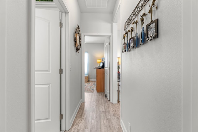 hall featuring plenty of natural light and light wood-type flooring