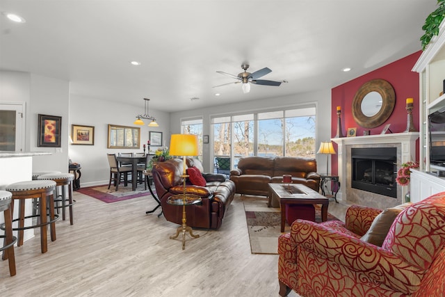 living room featuring ceiling fan and light hardwood / wood-style floors