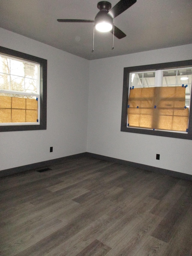 spare room featuring dark wood-type flooring and ceiling fan