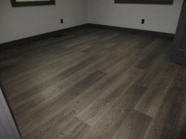 unfurnished room with dark hardwood / wood-style flooring