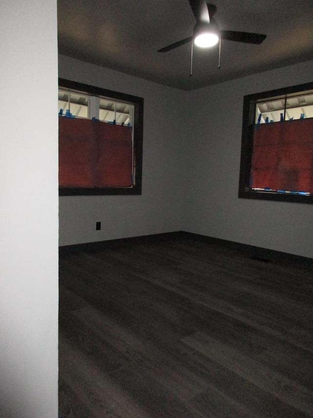 unfurnished room with dark hardwood / wood-style flooring and ceiling fan