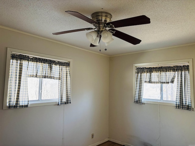 empty room with ornamental molding and a textured ceiling