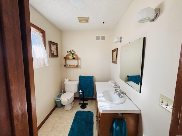 bathroom with vanity, a textured ceiling, and toilet