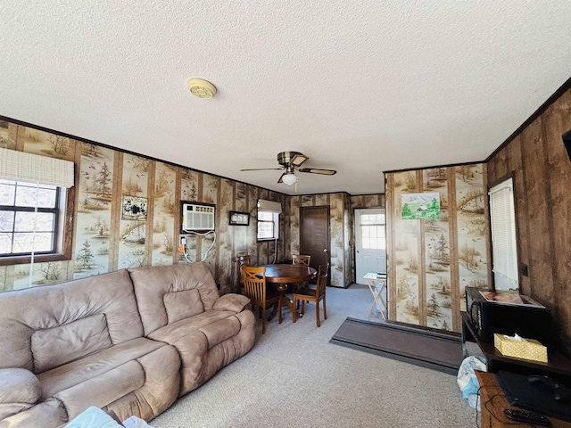 carpeted living room featuring ceiling fan, a textured ceiling, and a wall unit AC