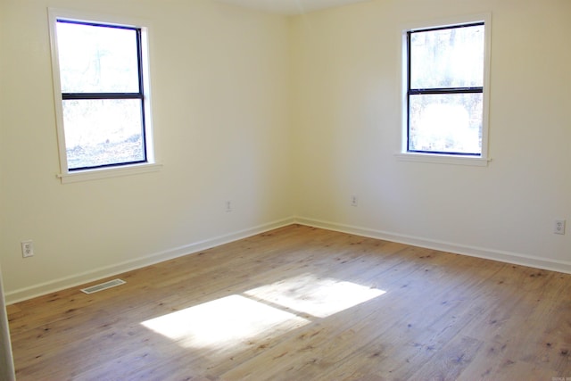 spare room featuring light hardwood / wood-style flooring and plenty of natural light