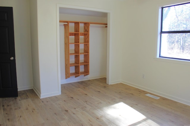 empty room featuring a healthy amount of sunlight and light hardwood / wood-style floors