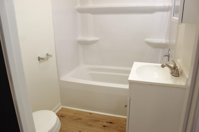 full bathroom with vanity, hardwood / wood-style floors,  shower combination, and toilet