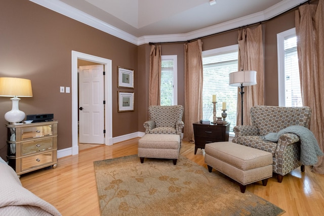 living area featuring hardwood / wood-style flooring and ornamental molding