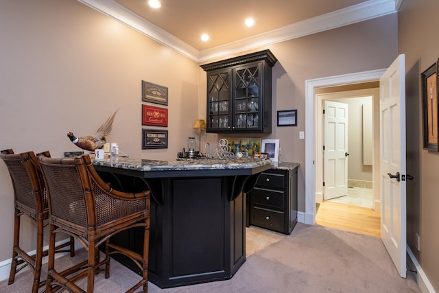 bar with crown molding, light stone counters, and light carpet