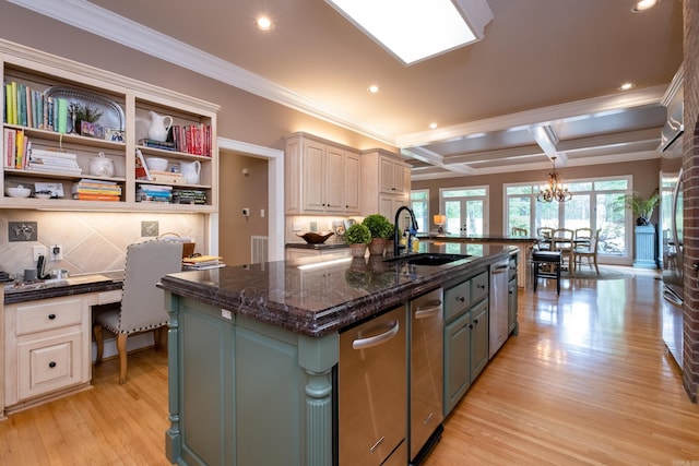 kitchen featuring coffered ceiling, sink, built in desk, beam ceiling, and a kitchen island with sink