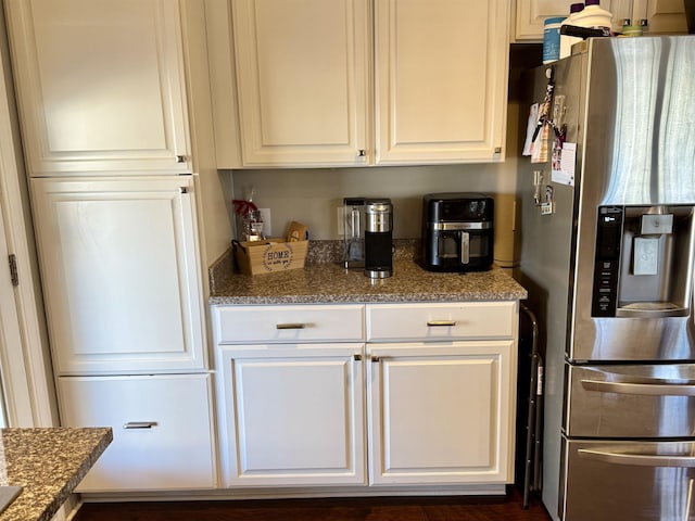 kitchen featuring stone countertops, white cabinets, and stainless steel fridge with ice dispenser