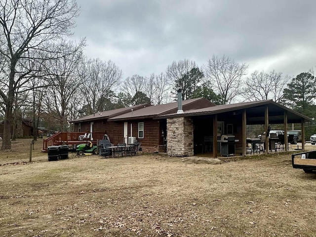 rear view of property featuring a yard and a deck