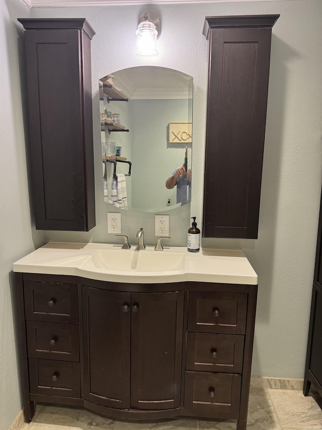 bathroom featuring crown molding and vanity