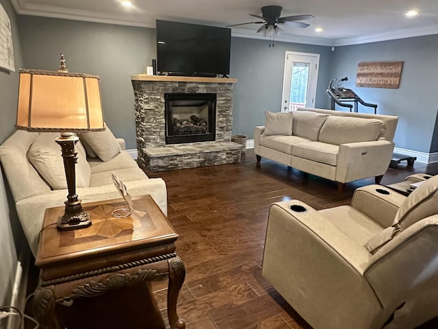 living room featuring dark wood-type flooring, crown molding, a fireplace, and ceiling fan