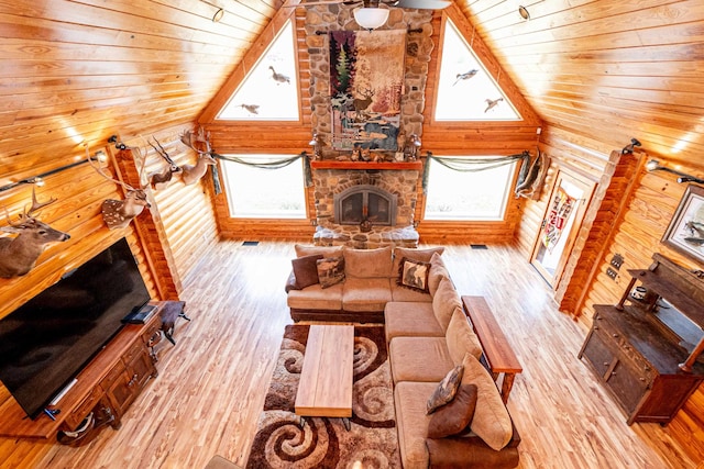 living room with hardwood / wood-style flooring, high vaulted ceiling, plenty of natural light, and a fireplace