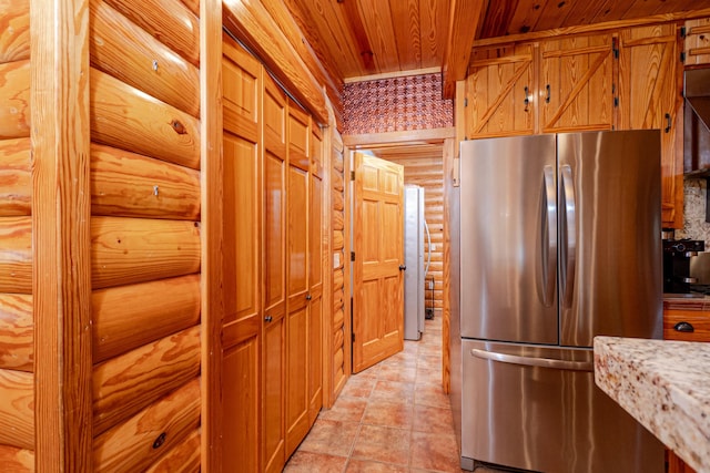 kitchen featuring wood ceiling, stainless steel fridge, and rustic walls