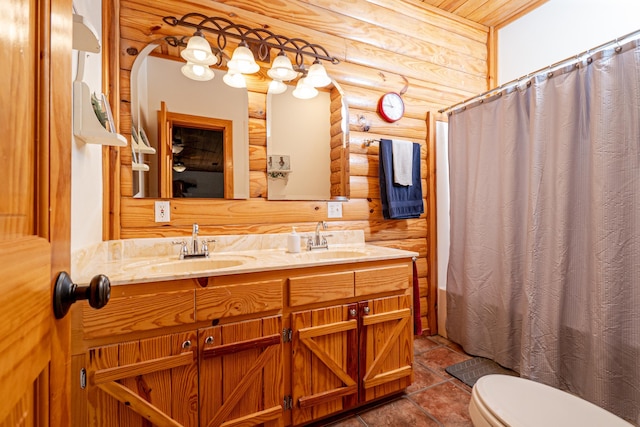 bathroom with vanity, toilet, and rustic walls